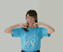 a woman wearing a blue t-shirt that says entertainment academy on it