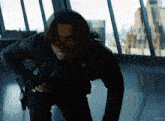 a man in a black jacket is standing in front of a window with kepler written on the bottom right