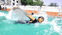 a person is swimming in a swimming pool with a man standing behind them