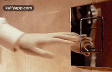 a close up of a person 's hand pressing a button in a bathroom .