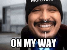 a man with a nose ring is smiling with the words on my way above his face