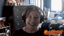 a woman is wearing headphones and smiling in front of a quest friends logo