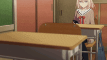 a girl in a school uniform sits at a desk