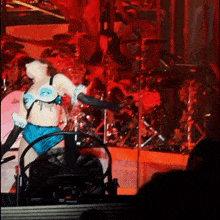 a woman in a blue and white outfit is dancing on stage
