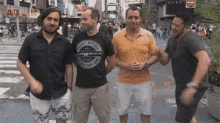 a group of men are standing in a line on a street .