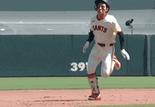 a baseball player wearing a giants jersey runs on the field