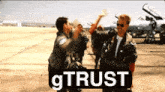 a man giving another man a high five in front of a sign that says gtrust
