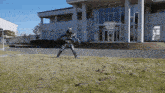 a man in a robot costume is jumping in front of a building