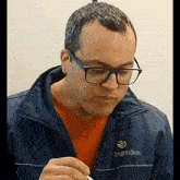 a man wearing glasses and a jacket that says ingredion on it