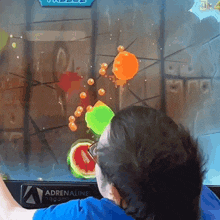 a man is playing a game on a monitor that says adrenaline on it