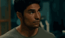 a man in a green shirt is looking to the side .