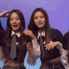 two girls wearing ties and crop tops are dancing