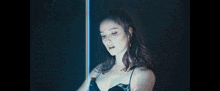 a woman is standing in front of a blue light and looking down .