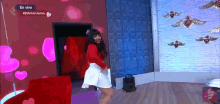 a woman in a red top and white skirt is dancing in front of a brick wall with the words en vivo on it