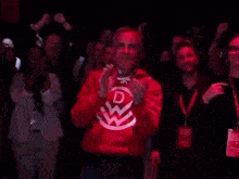 a man in a red sweatshirt with the letter d on it is clapping