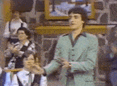 a man in a green suit is standing in front of a crowd