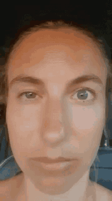 a close up of a woman 's face with blue eyes looking at the camera .