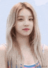 a woman with blonde hair is wearing a striped tank top