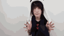 a young boy is wearing a panda hat and making a funny face