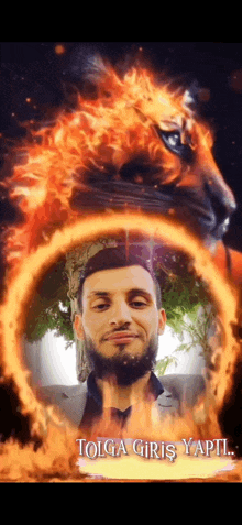 a man with a beard is surrounded by flames and says tolga giriş yapti on the bottom