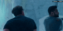 two men are standing in front of a wall with the words pranay and varma on it