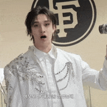 a young man in a white jacket with bang chan written on the bottom