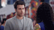 a man in a suit and a woman in a blue dress are standing next to each other and the words hotstar are on the bottom