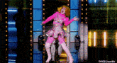a woman in a pink dress and pink boots dancing