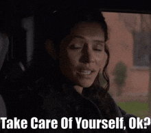 a woman is sitting in a car with the words take care of yourself ok written below her