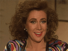 a woman in a colorful shirt is smiling with her mouth wide open