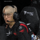 a man wearing glasses and headphones is sitting in front of a chair that says secret lab