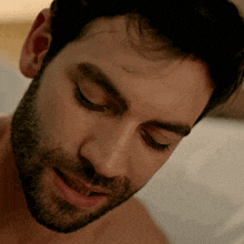 a close up of a man 's face with his eyes closed and his mouth open