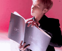 a man in a suit is reading a book called infinity