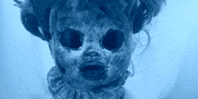 a close up of a scary doll 's face in blue light .