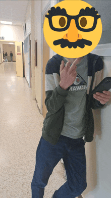 a man wearing a shirt that says hawaii is standing in a hallway