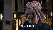 a man with a squid head is standing in front of a sign that says tjahelo
