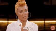 a woman wearing hoop earrings and a head scarf says got it