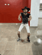 a man wearing a cowboy hat and a black shirt with the word victory on it