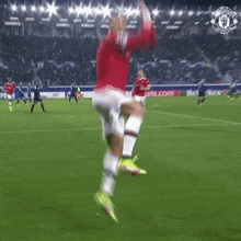 a man in a red jersey with the number 7 on it jumps in the air on a soccer field