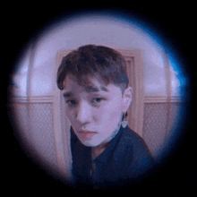 a close up of a person 's face through a peephole in a door .