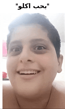 a young boy with a black eye is smiling with arabic writing above his face