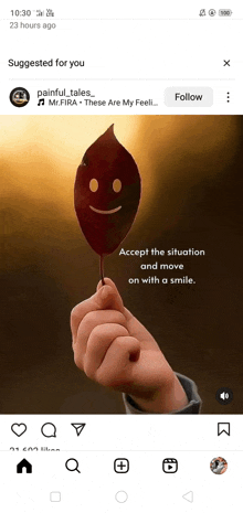 a person is holding a leaf with a smiley face on it in their hand .