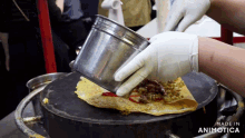 a person is pouring ketchup on an omelet with the words made in animatica in the corner
