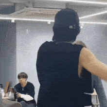 a man in a black tank top is standing in a room