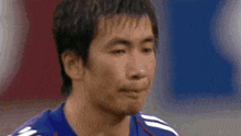a close up of a man 's face wearing a soccer jersey .