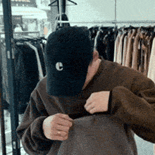 a man wearing a black hat with a letter c on it