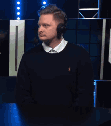 a man wearing headphones says yeah in front of a computer monitor