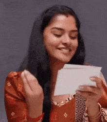 a woman is holding a piece of paper in her hand .