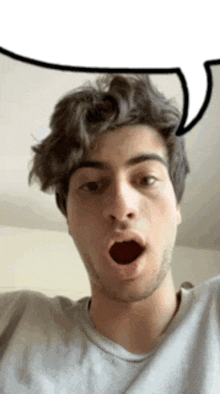 a young man with a beard is making a funny face with his mouth open .