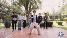a group of young men are standing next to each other on a brick sidewalk .